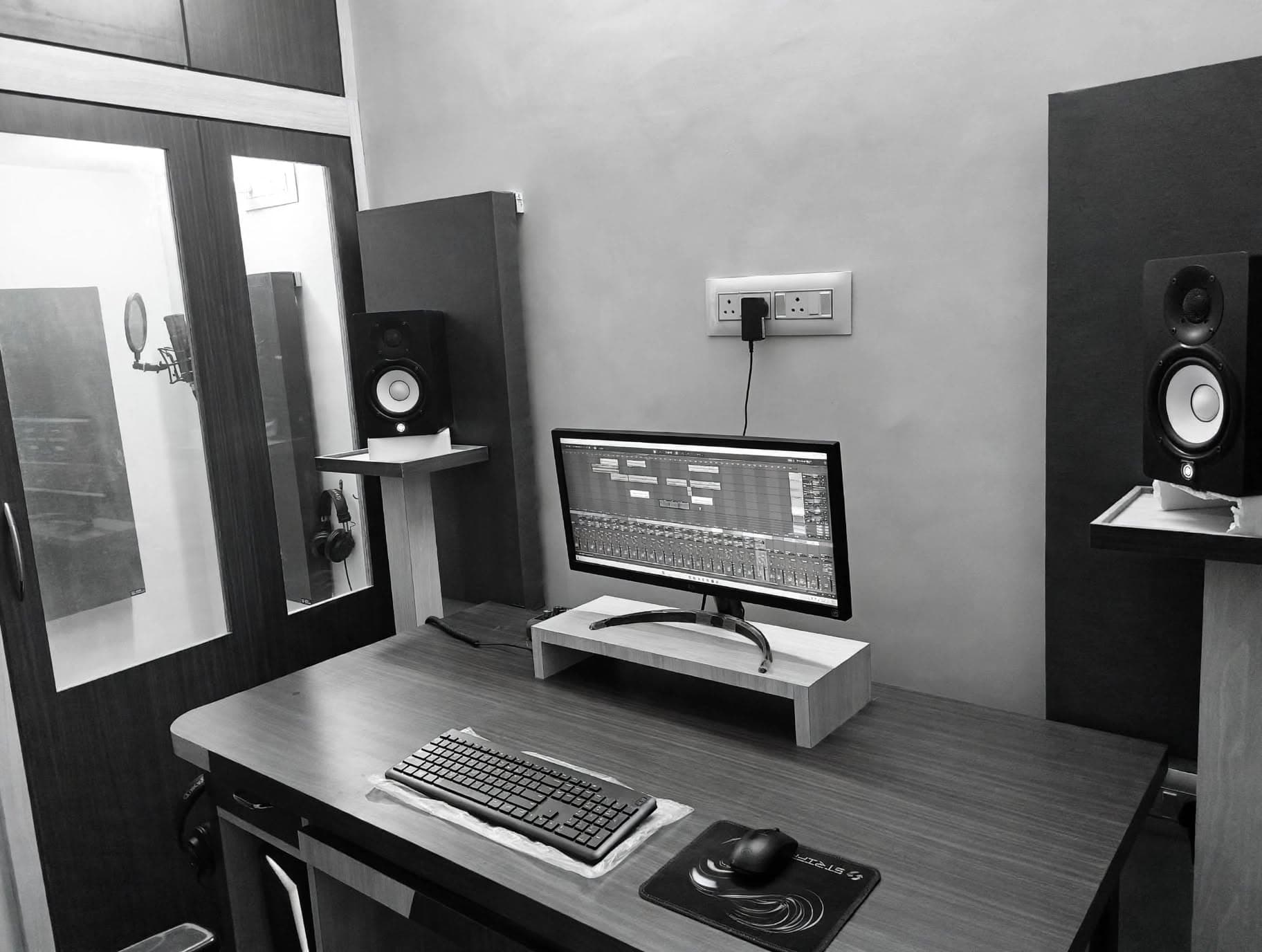 Control room desk with a view into the vocal recording booth