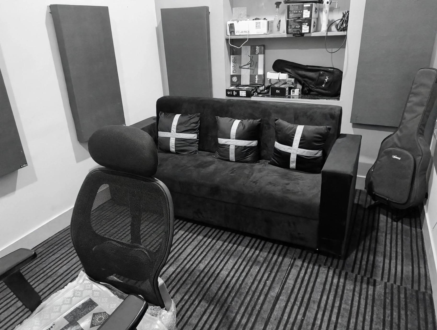 Studio lounge seating area with acoustic panels and instrument cases
